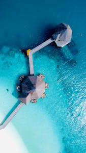 A stunning aerial view of overwater villas in the Maldives amidst turquoise waters.